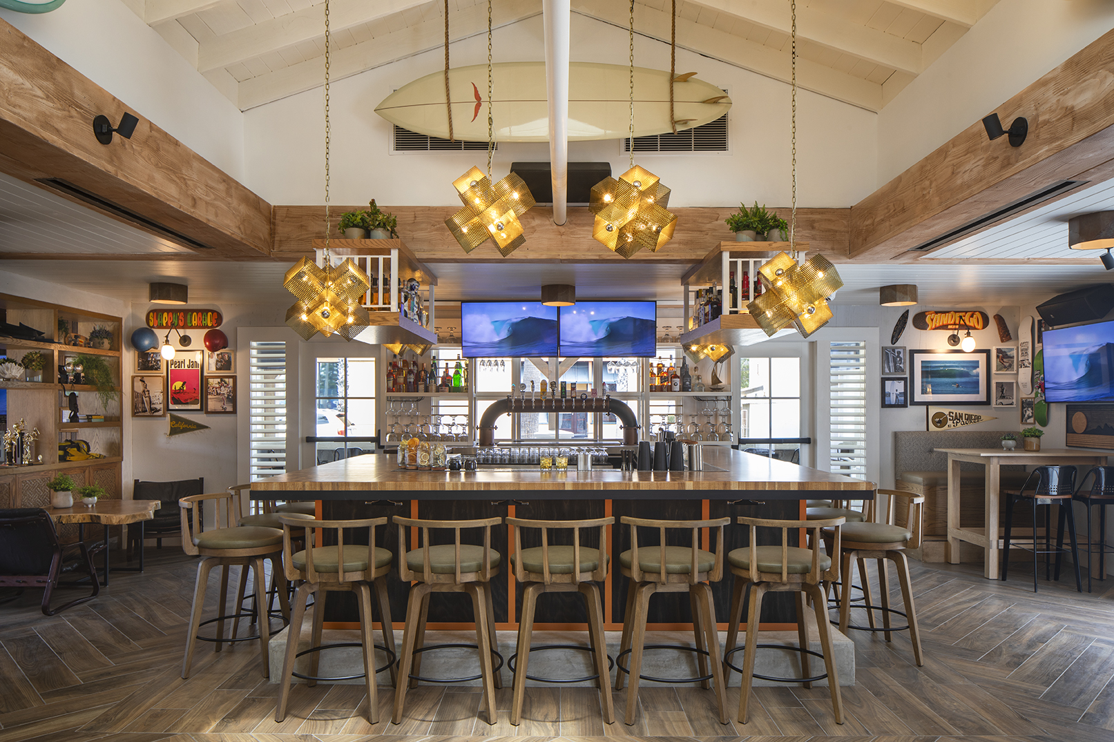 Hideaway Pacific Beach bar with surfboard, brass pendant lights and open kitchen bar seating