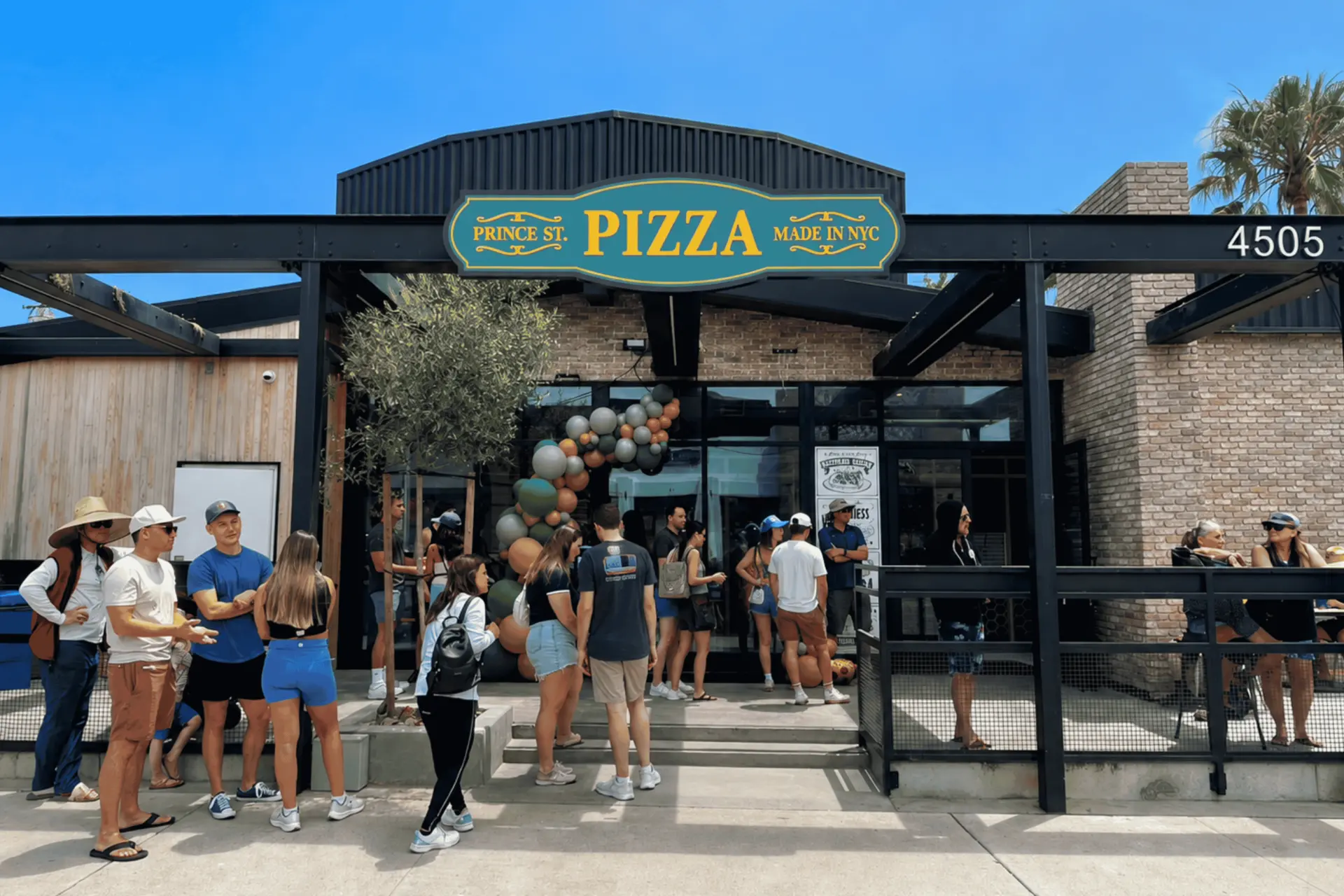 Prince St. Pizza storefront in Pacific Beach with guests lined up under the teal and gold sign